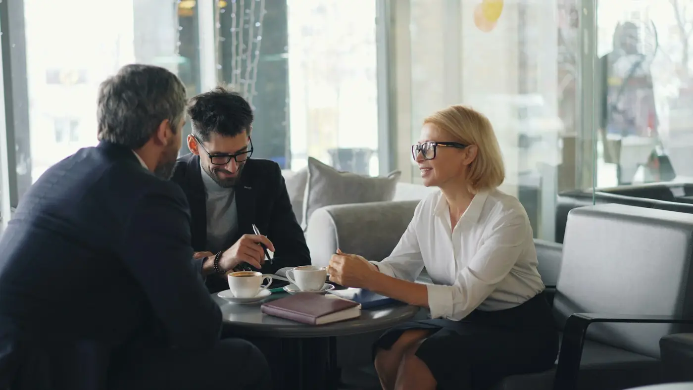 Business owners and an adviser talking over coffee